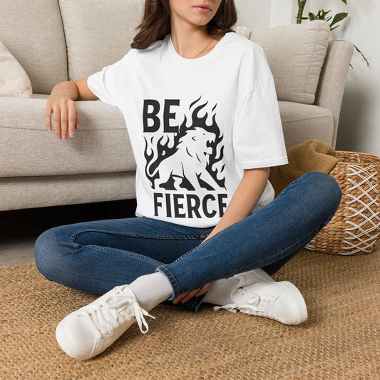 Person wearing a white t-shirt with a graphic design and text, sitting on the floor in a living room.
